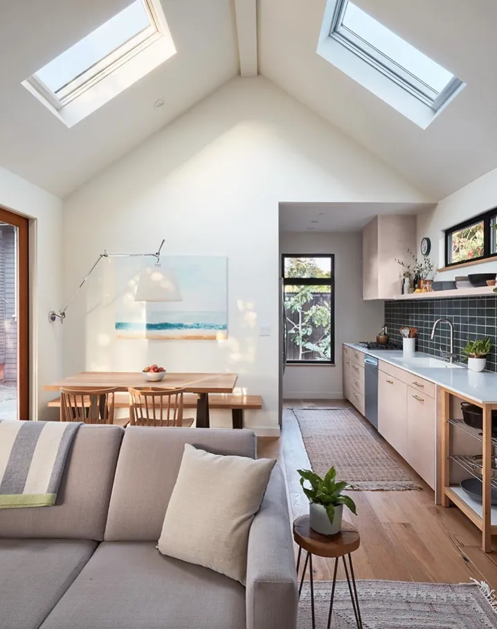 Vaulted ADU living room and kitchen with two skylights and a grey sofa